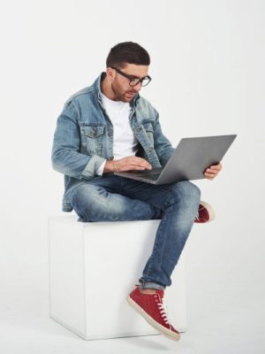 Handsome young man with laptop and check his timetable on white background.